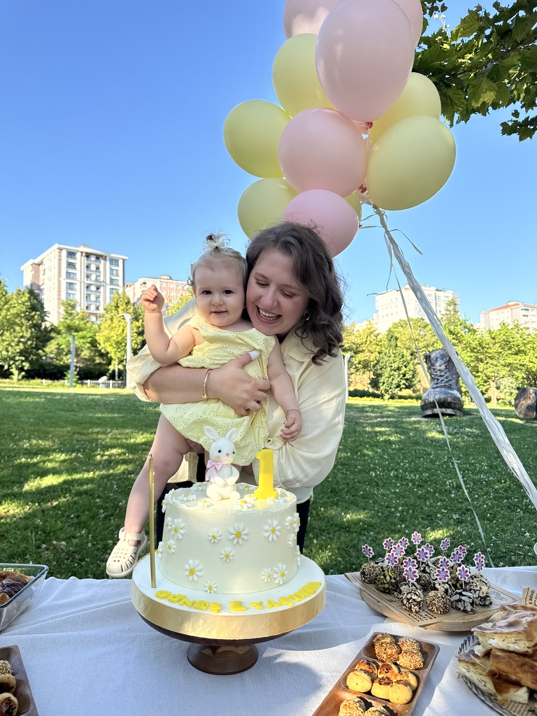 Güneş, annesi ve birinci yaş günü pastasıyla parkta